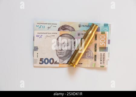 Banconote ucraine di 500 e 1000 tagli e una custodia per cartucce si trovano su sfondo bianco, affari e finanza, denaro Foto Stock