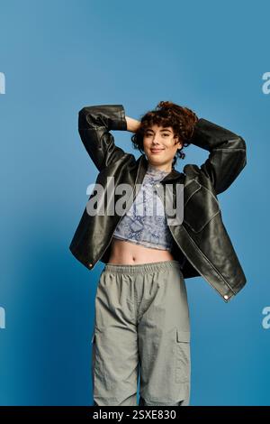 Una giovane donna sicura di sé mette in mostra il suo outfit alla moda in un ambiente vivace. Foto Stock