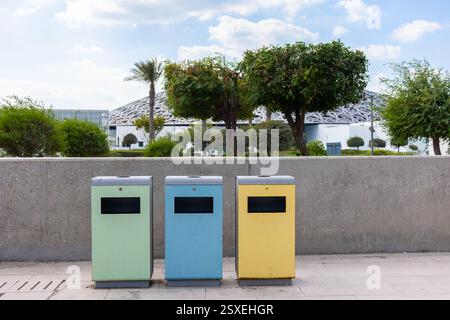 Contenitori di riciclaggio blu, gialli e verdi per rifiuti separati in strada ad Abu Dhabi, Emirati Arabi. Foto di alta qualità Foto Stock