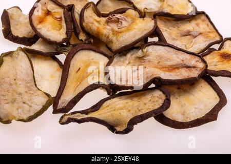 Primo piano di un mucchio di fette di pere essiccate isolate su sfondo bianco. Sana alimentazione vegetariana cruda da da sottili patatine di frutta dal sapore dolce e aspro Foto Stock