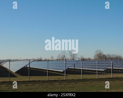 stazione a pannelli solari nelle zone rurali durante il periodo invernale, pannelli solari dietro recinzioni in filo metallico nelle giornate di sole Foto Stock