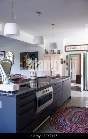 Bilance da cucina e tappeto con cucina in granito a Bayfield Hall, una casa di campagna ristrutturata del XVIII secolo a Norfolk, Regno Unito. Foto Stock