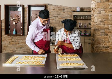 Fornai che preparano dolci in cucina durante il corso di cucina Foto Stock