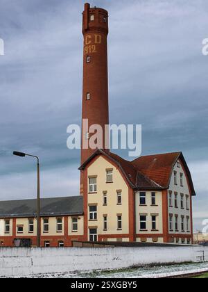 Torre in mattoni rossi con annesso edificio storico sotto un cielo invernale nuvoloso a Magdeburgo, Germania. Foto Stock