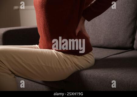 Giovane donna che soffre di mal di schiena o reni a casa foto di scorta Foto Stock