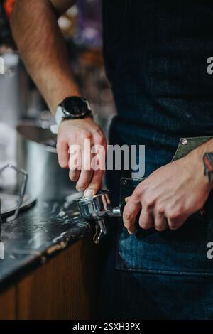 Primo piano del barista che prepara l'espresso con attrezzature professionali per il caffè Foto Stock