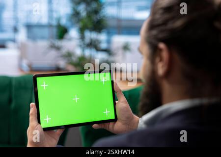 Un giovane imprenditore in un ufficio aziendale monitora le condizioni del mercato, definendo obiettivi finanziari strategici e prendendo decisioni di leadership per una redditività a lungo termine. Etica del lavoro. Foto Stock