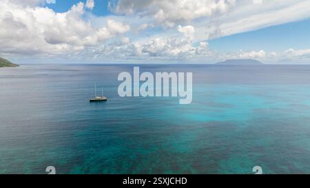 Ampia vista dell'oceano turchese che si estende all'orizzonte con nuvole sparse. Seychelles, Praslin. Foto Stock