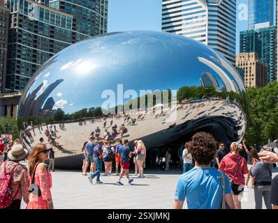 Chicago, Illinois, Stati Uniti - 18 luglio 2024: La folla si riunisce intorno a una grande scultura riflettente a Chicago, godendosi il sole e lo skyline della città. Foto Stock