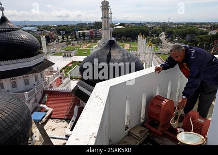Banda Aceh, Aceh, Indonesia. 25 febbraio 2025. Gli ufficiali della moschea ispezionano le apparecchiature a sirena per iftar e imsak alla Baiturrahman Grand Mosque Tower, banda Aceh City, provincia di Aceh, Indonesia martedì 25 febbraio, 2025. le sirene dotate di altoparlanti sono utilizzate durante il Ramadan per segnalare l'arrivo di Iftar e Imsak per i musulmani, che sono stati collegati ad apparecchiature radio trasmesse in tutta la regione. Crediti: Khairu Syukrillah/ZUMA Press Wire/ZUMA Wire/Alamy Live News Foto Stock