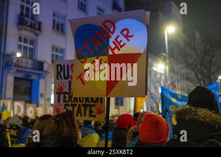 Varsavia, Polonia. 24 febbraio 2025. Un manifestante ha un cartello con la scritta "stare insieme" mentre partecipa a una manifestazione per celebrare il terzo anniversario della guerra su vasta scala della Russia contro l'Ucraina. Centinaia di ucraini che vivevano in Polonia e i loro sostenitori si sono riuniti fuori dall'ambasciata Ucraina a Varsavia per celebrare il terzo anniversario dell'invasione russa dell'Ucraina su vasta scala. (Foto di Marek Antoni Iwanczuk/SOPA Images/Sipa USA) credito: SIPA USA/Alamy Live News Foto Stock