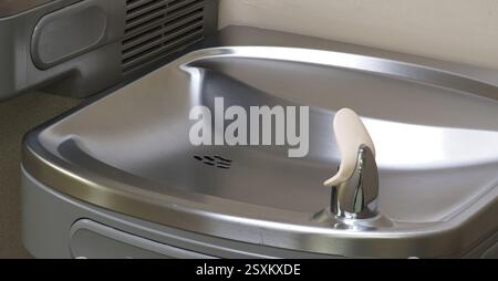 Fontana in acciaio inox montata su una parete Foto Stock