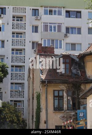 Una miscela di architettura vecchia e nuova a Bucarest mostra le differenze tra un edificio storico in deterioramento e un moderno complesso di appartamenti nelle vicinanze Foto Stock