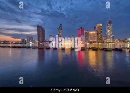 Lo skyline illuminato della città di ho chi Minh, Thành phố Hồ Chí Minh, Saigon, Sài Gòn, si riflette nel fiume Saigon, Sông Sài Gòn. Foto Stock