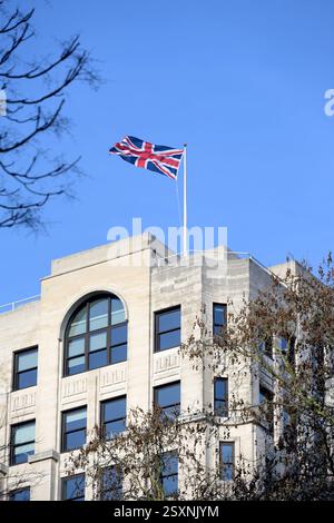 Londra, Regno Unito. Union Flag che vola dal tetto dell'Adelphi Building nello Strand, visto dai Victoria Embankment Gardens Foto Stock