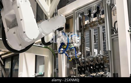 Moderno braccio robotico che esegue attività su una linea di produzione automatizzata in una fabbrica high-tech. Foto Stock