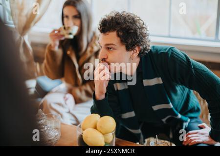 Giovani adulti in un ambiente caffetteria che si godono un momento rilassato e ponderato Foto Stock