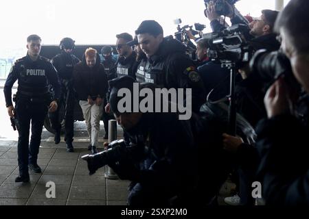 Bucarest, Romania. 25 febbraio 2025. Mohamed Amra è scortato da agenti di polizia sull'aereo che lo trasporterà in Francia, all'aeroporto di Bucarest, Otopeni, Romania, il 25 febbraio 2025. Amra era in fuga da quando è stata liberata nel maggio 2024 in un'imboscata che ha lasciato due agenti di prigione morti. La polizia francese ha arrestato 10 persone sospettate di aiutare il condannato, un procuratore ha dichiarato il 23 febbraio. Foto di Octav Ganea/Inquam Photos/ABACAPRESS. COM credito: Abaca Press/Alamy Live News Foto Stock