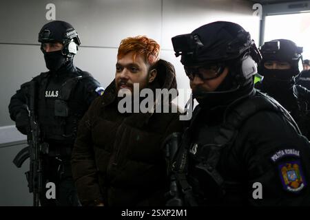 Bucarest, Romania. 25 febbraio 2025. Mohamed Amra è scortato da agenti di polizia sull'aereo che lo trasporterà in Francia, all'aeroporto di Bucarest, Otopeni, Romania, il 25 febbraio 2025. Amra era in fuga da quando è stata liberata nel maggio 2024 in un'imboscata che ha lasciato due agenti di prigione morti. La polizia francese ha arrestato 10 persone sospettate di aiutare il condannato, un procuratore ha dichiarato il 23 febbraio. Foto di Octav Ganea/Inquam Photos/ABACAPRESS. COM credito: Abaca Press/Alamy Live News Foto Stock
