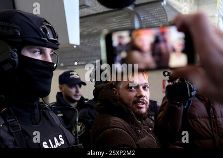 Bucarest, Romania. 25 febbraio 2025. Mohamed Amra è scortato da agenti di polizia sull'aereo che lo trasporterà in Francia, all'aeroporto di Bucarest, Otopeni, Romania, il 25 febbraio 2025. Amra era in fuga da quando è stata liberata nel maggio 2024 in un'imboscata che ha lasciato due agenti di prigione morti. La polizia francese ha arrestato 10 persone sospettate di aiutare il condannato, un procuratore ha dichiarato il 23 febbraio. Foto di Octav Ganea/Inquam Photos/ABACAPRESS. COM credito: Abaca Press/Alamy Live News Foto Stock
