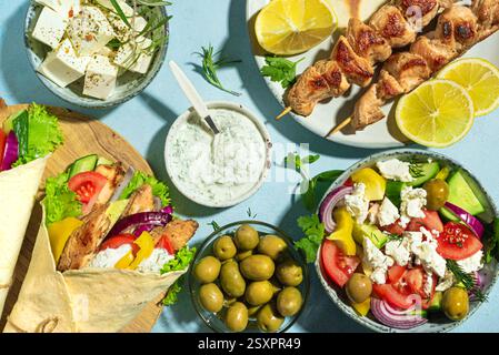 Assortimento di piatti greci. Gyros wrap, souvlaki, pita, insalata greca, tzatziki, formaggio feta, olive per un pranzo salutare. Piatti tradizionali greci diversi Foto Stock
