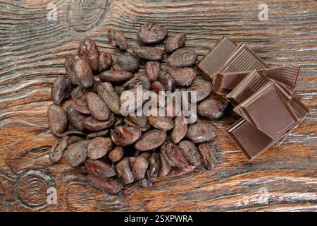 Cioccolato fondente rotto e fagioli di cacao sul tavolo Foto Stock