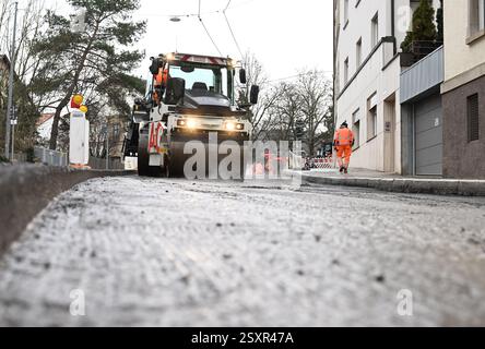 Stoccarda, Germania. 25 febbraio 2025. Un rullo leviga e comprime la superficie stradale appena applicata in un cantiere di rinnovo stradale. Crediti: Bernd Weißbrod/dpa/Alamy Live News Foto Stock