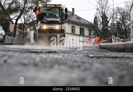 Stoccarda, Germania. 25 febbraio 2025. Un rullo leviga e comprime la superficie stradale appena applicata in un cantiere di rinnovo stradale. Crediti: Bernd Weißbrod/dpa/Alamy Live News Foto Stock