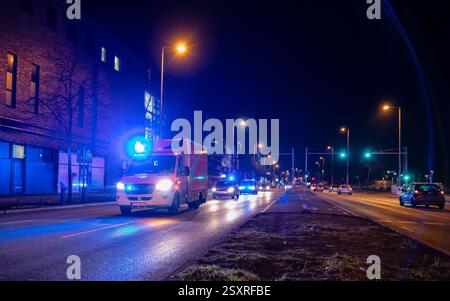 Ambulanza notturna a Berlino, Germania, ambulanza, auto della polizia in azione su strada Foto Stock