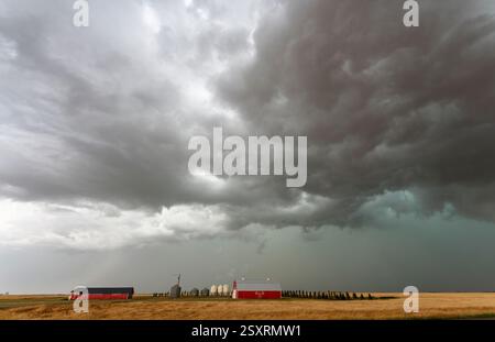 Le nuvole che si incombono su supercell creano un cielo spettacolare sopra una fattoria nelle praterie canadesi Foto Stock