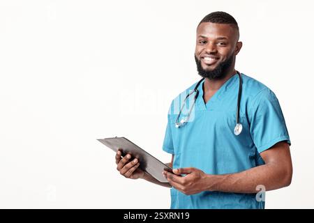 Dottore afroamericano sorridente in uniforme blu con referto medico Foto Stock