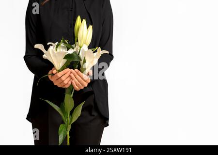 Giovane donna con bouquet funebre di fiori di giglio su sfondo bianco Foto Stock