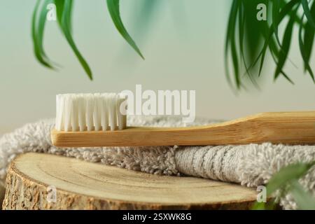 Spazzolino da denti in legno su asciugamano con sfondo naturale - concetto di ecologia e prodotti naturali Foto Stock