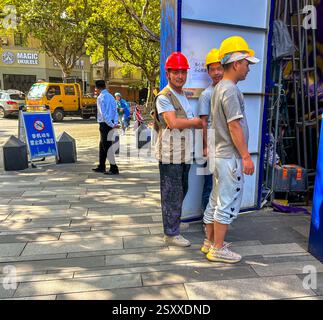 Shanghai, Cina, Street Scenes, Group People, Chinese migrants, dipendenti di uomini con Hard Hats, in piedi, in cantiere, all'esterno di un gruppo di lavoratori Foto Stock