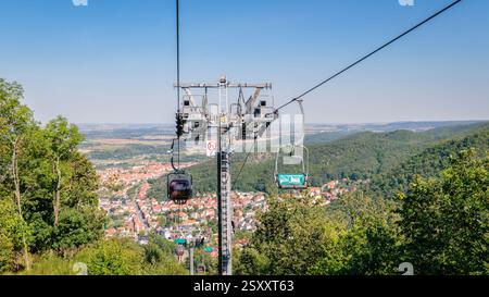 Thale, Germania – 27 agosto 2024: I turisti in sella alla seggiovia che collega Thale con la falesia di granito alta 403 metri Rosstrappe godono di una splendida vista Foto Stock