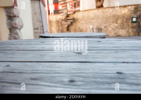 Vecchio tavolo in legno nella caffetteria della strada - primo piano di un tavolo in legno vintage con finiture usurate in ambiente urbano, spazio per copie Foto Stock