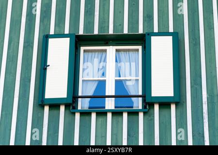 Stile rustico: Finestra in una casa rustica - primo piano di una finestra con tende contro pareti di legno in stile tradizionale Foto Stock