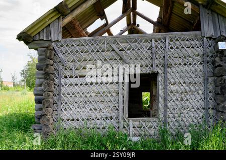 Frammento di una vecchia casa di legno abbandonata in estate Foto Stock