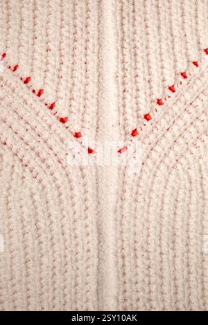 Maglione in lana lavorata a maglia su una superficie leggera a taglio lento. Trama di sfondo Foto Stock