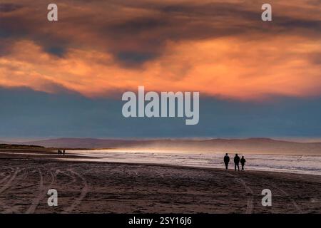 Persone che camminano sulla sabbia al crepuscolo, Downhill Beach, Londonderry, Irlanda Foto Stock