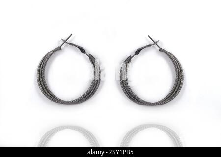 Orecchini a cerchio rotondi in argento nero, su sfondo bianco, Orecchini in argento (indiano, arabo, africano, egiziano), Orecchini in argento ossidato, ex moda Foto Stock