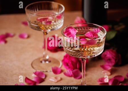 Due bicchieri di champagne con petali di rosa. Foto Stock