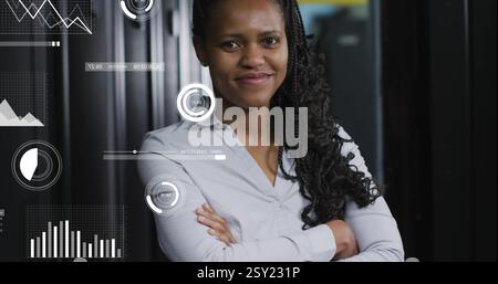 Immagine dell'elaborazione dei dati e dei diagrammi su una lavoratrice birazziale che sorride nella sala server Foto Stock