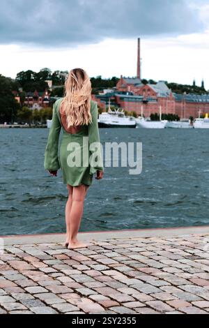 donna che cammina a piedi nudi vicino al mare Foto Stock
