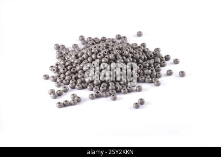 Perline distribuite su sfondo bianco. Sfondo o trama delle perline. Primo piano, macro, viene utilizzato per rifinire gli abiti alla moda. crea collana o perline con perline Foto Stock