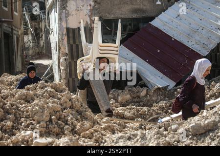 Tulkarm, Palestina. 26 febbraio 2025. Le famiglie palestinesi portano con sé i loro effetti personali, mentre fuggono dal campo profughi di Nour Shams. Le forze israeliane hanno permesso ai residenti di recuperare i loro effetti personali dopo aver emesso avvisi di demolizione per diverse case, nel mezzo di un assalto di settimane in Cisgiordania che ha allontanato circa 30.000 palestinesi dalle loro case all'interno del campo profughi di Nur Shams. Credito: SOPA Images Limited/Alamy Live News Foto Stock