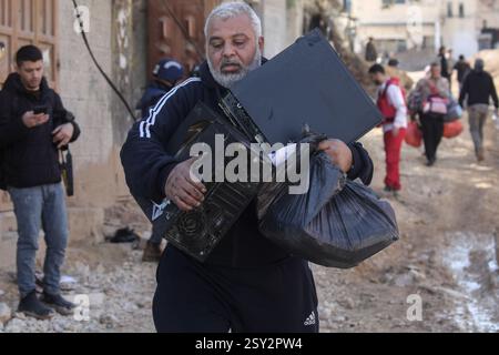 Tulkarm, Palestina. 26 febbraio 2025. Un palestinese porta i suoi effetti personali mentre fugge dal campo profughi di Nour Shams. Le forze israeliane hanno permesso ai residenti di recuperare i loro effetti personali dopo aver emesso avvisi di demolizione per diverse case, nel mezzo di un assalto di settimane in Cisgiordania che ha allontanato circa 30.000 palestinesi dalle loro case all'interno del campo profughi di Nur Shams. Credito: SOPA Images Limited/Alamy Live News Foto Stock