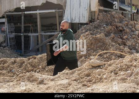 Tulkarm, Palestina. 26 febbraio 2025. Un palestinese porta i suoi effetti personali mentre fugge dal campo profughi di Nour Shams. Le forze israeliane hanno permesso ai residenti di recuperare i loro effetti personali dopo aver emesso avvisi di demolizione per diverse case, nel mezzo di un assalto di settimane in Cisgiordania che ha allontanato circa 30.000 palestinesi dalle loro case all'interno del campo profughi di Nur Shams. Credito: SOPA Images Limited/Alamy Live News Foto Stock
