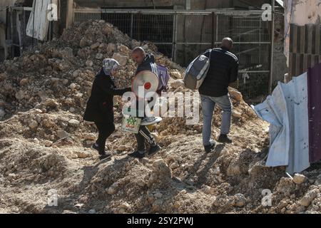 Tulkarm, Palestina. 26 febbraio 2025. Le famiglie palestinesi portano con sé i loro effetti personali, mentre fuggono dal campo profughi di Nour Shams. Le forze israeliane hanno permesso ai residenti di recuperare i loro effetti personali dopo aver emesso avvisi di demolizione per diverse case, nel mezzo di un assalto di settimane in Cisgiordania che ha allontanato circa 30.000 palestinesi dalle loro case all'interno del campo profughi di Nur Shams. Credito: SOPA Images Limited/Alamy Live News Foto Stock