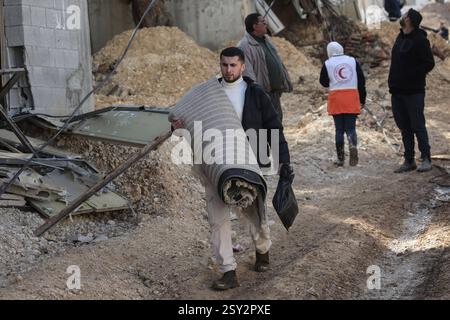 Tulkarm, Palestina. 26 febbraio 2025. Le famiglie palestinesi portano con sé i loro effetti personali, mentre fuggono dal campo profughi di Nour Shams. Le forze israeliane hanno permesso ai residenti di recuperare i loro effetti personali dopo aver emesso avvisi di demolizione per diverse case, nel mezzo di un assalto di settimane in Cisgiordania che ha allontanato circa 30.000 palestinesi dalle loro case all'interno del campo profughi di Nur Shams. Credito: SOPA Images Limited/Alamy Live News Foto Stock